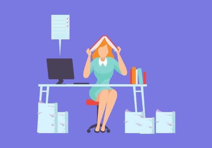 overwhelmed woman at desk with paperwork