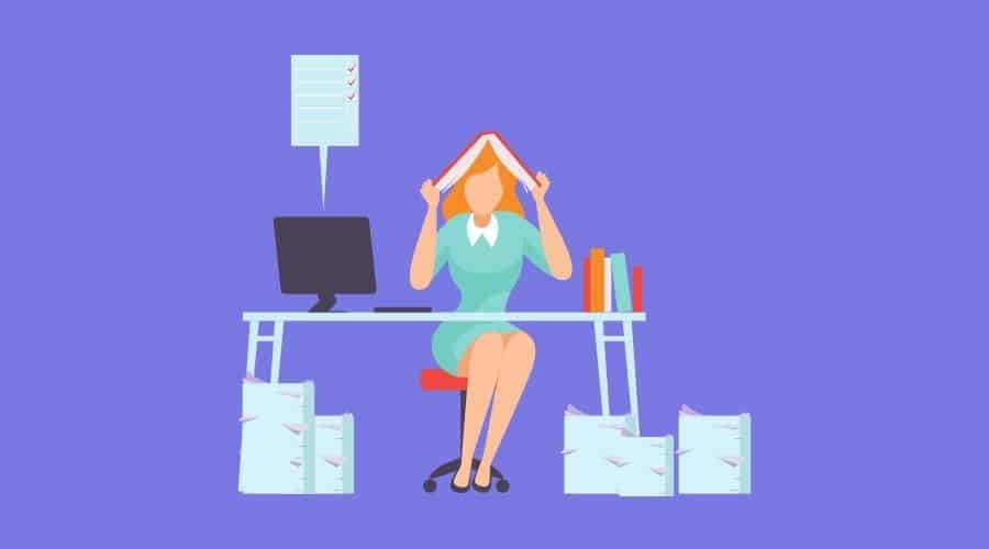 overwhelmed woman at desk with paperwork